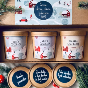 Darilni paket theBOX Vroča trojica s temno in belo vročo čokolado ter masala chai lattejem znamke Tejst v praznično okrašeni škatli.
